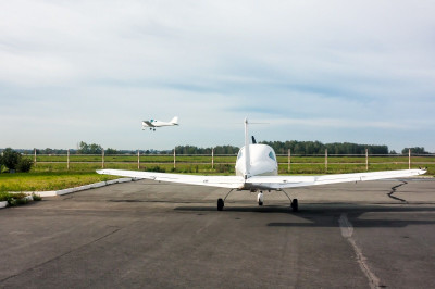 one-small-sports-plane-stands-parking-lot-airfield-other-airplane-comes-landing.jpg